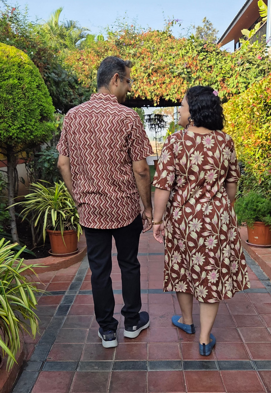 Two people walking together on a tiled path with greenery around
