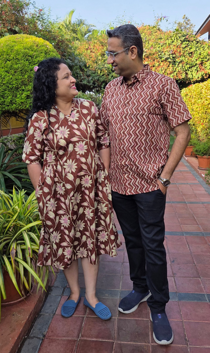 Couple standing together on a tiled path with greenery in the background