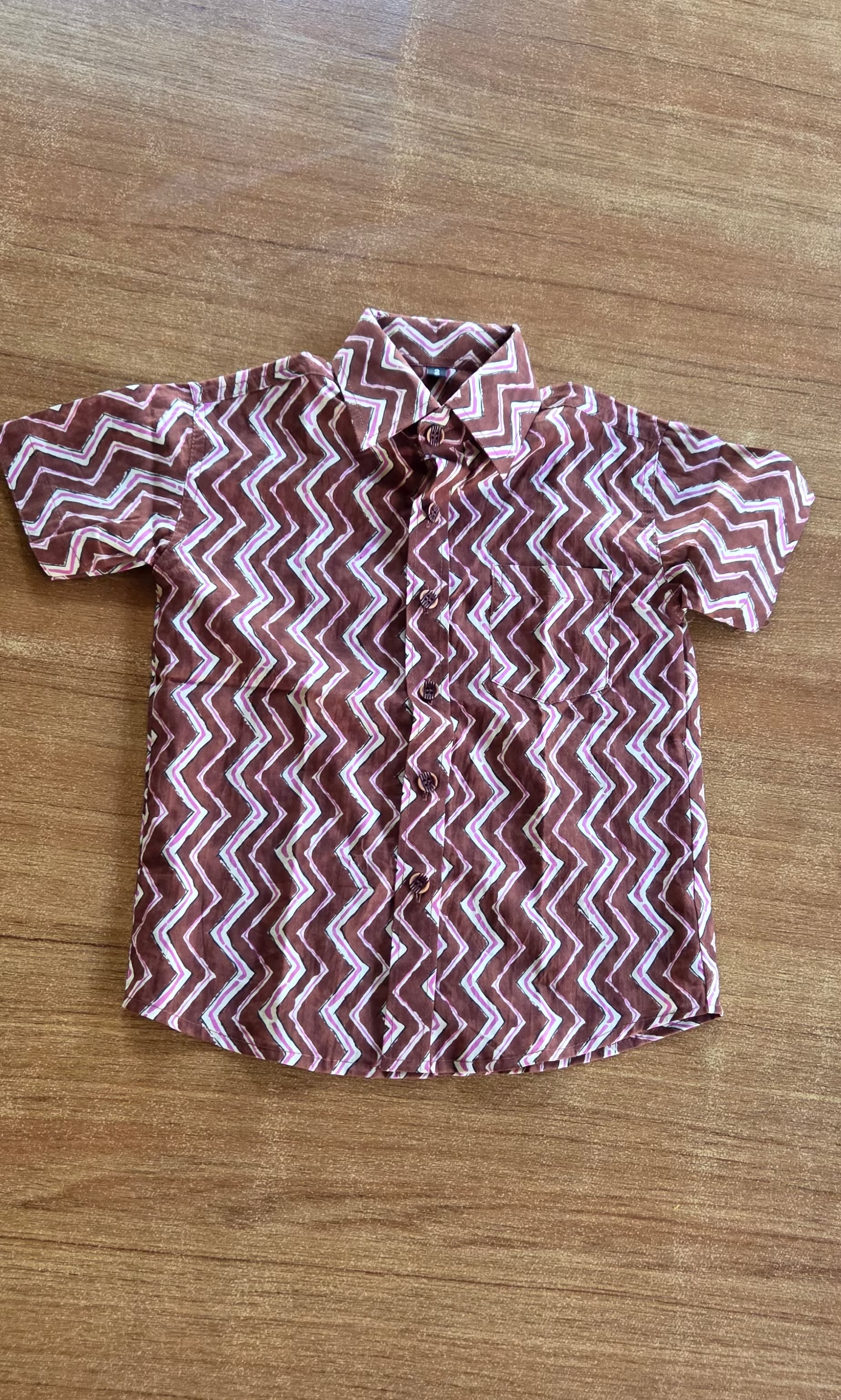 Short-sleeve shirt with zigzag pattern on a wooden surface