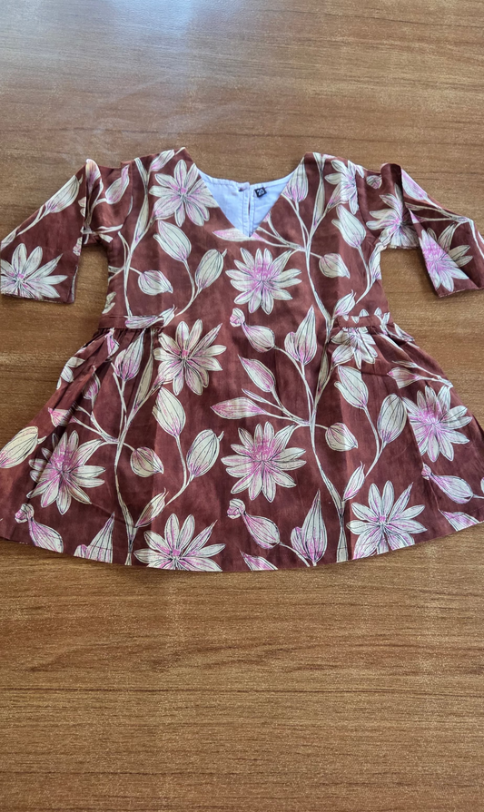 Floral-patterned dress on a wooden surface