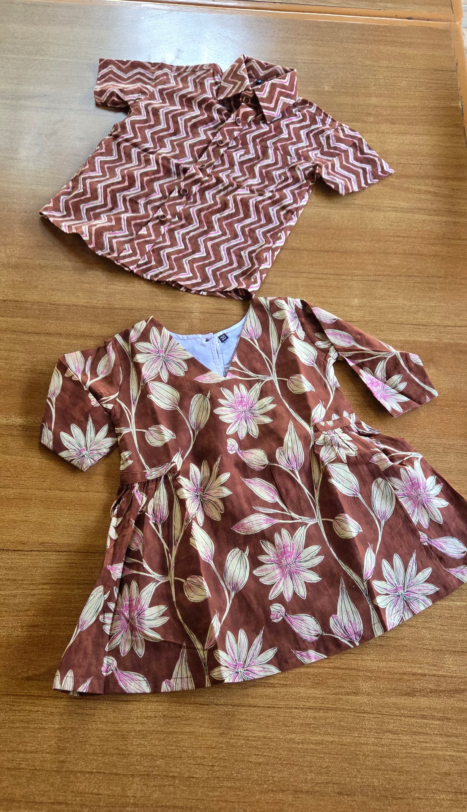 Children's dress with floral pattern and headband on a wooden surface
